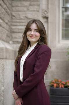 headshot of woman standing in front of wall